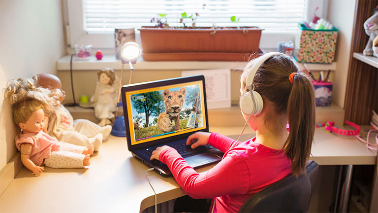 girl reading a digital kids magazine on a laptop