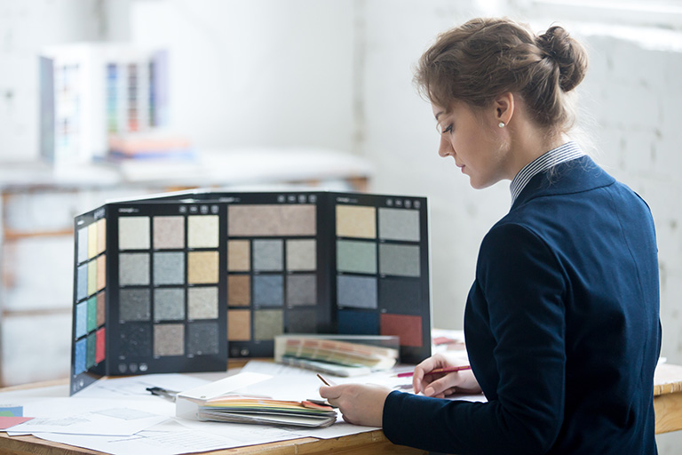 designerin wählt materialien für einen möbelkatalog aus